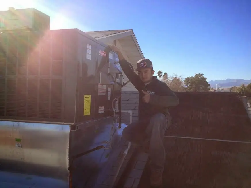 HVAC technician performing AC Tune-Up on a rooftop unit in Garden Acres